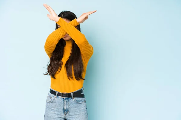 Mujer India Joven Aislada Sobre Fondo Azul Manteniendo Dos Brazos —  Fotos de Stock