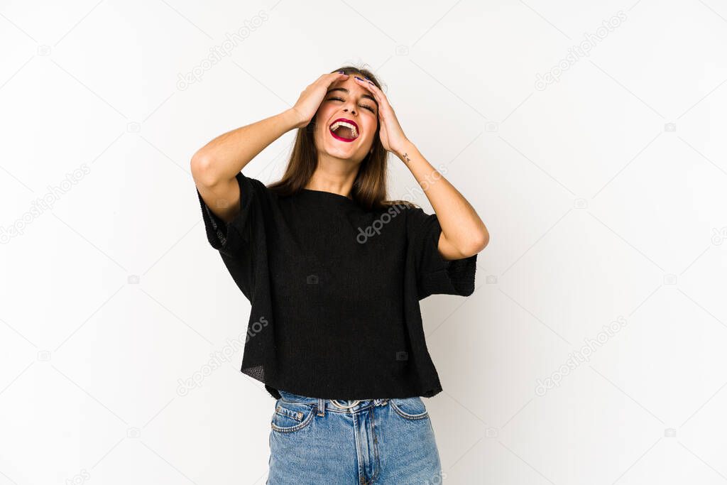 Young caucasian woman isolated on white background laughs joyfully keeping hands on head. Happiness concept.