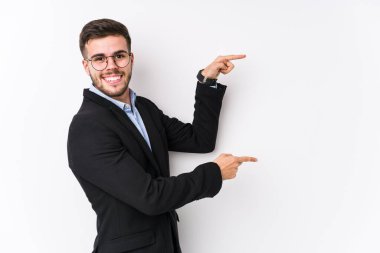 Beyaz arka planda poz veren beyaz tenli genç beyaz iş adamı genç beyaz iş adamını işaret ederek heyecanlandırıyor..