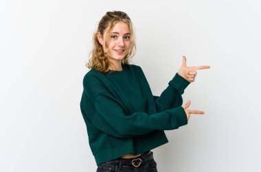 Beyaz arka plandaki genç beyaz kadın işaret parmağıyla işaret ettiği için heyecanlı..