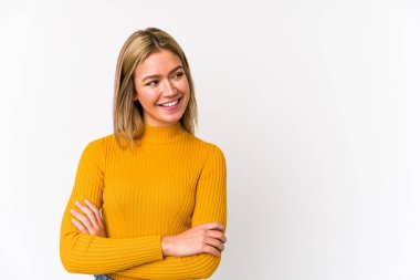 Sarışın, beyaz tenli, soyutlanmış, kollarını kavuşturarak gülümseyen bir kadın..