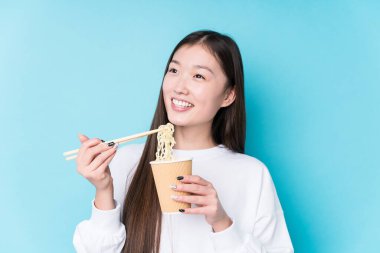 Genç Japon kadın erişte yiyor.