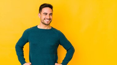 Kafkasyalı genç adam sarı fırında izole edilmiş, kendine güveni tam, elleri kalçasında..