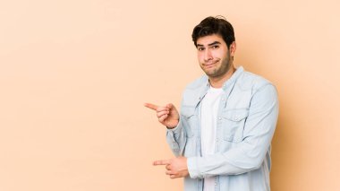 Bej arka planda izole edilmiş genç adam işaret parmağıyla fotokopi alanını göstererek şok oldu..