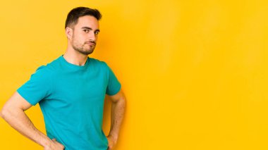 Kafkasyalı genç adam sarı fırında izole edilmiş hoşnutsuzca kaşlarını çatmış, kollarını kavuşturmuş..