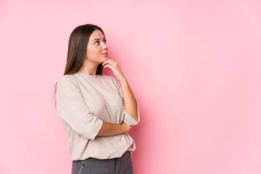 Kafkasyalı genç bir kadın yalnız poz veriyor. Şüpheli ve şüpheci bir ifadeyle yana bakıyor..