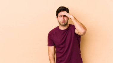 Bej arka planda izole edilmiş genç bir adam tapınaklara dokunuyor ve başı ağrıyor..