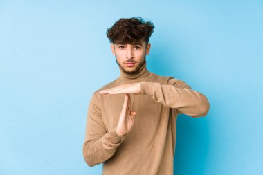 Genç Arap bir adam tecrit edilmiş, mola işareti yapıyor..