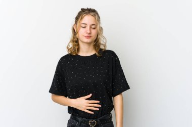 Beyaz sırtlı genç beyaz kadın karnına dokunuyor, nazikçe gülümsüyor, yemek yiyor ve tatmin oluyor..