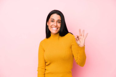 Pembe arka planda izole edilmiş genç beyaz kadın göz açıp kapayıncaya kadar elinde iyi bir el hareketi tutuyor..