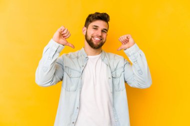 Sarı arka planda izole edilmiş genç beyaz adam gururlu ve kendinden emin hissediyor, örnek olarak.