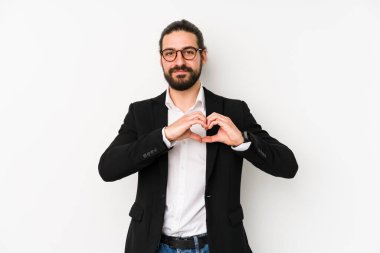 Beyaz arka planda izole edilmiş beyaz bir iş adamı gülümsüyor ve elleriyle kalp şeklini gösteriyor..