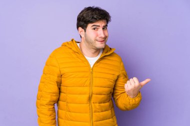 Mor arka planda izole edilmiş genç adam işaret parmağıyla fotokopi alanını göstererek şok oldu..