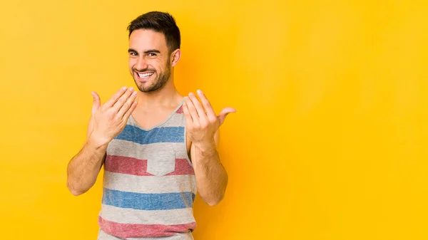 Young Caucasian Man Isolated Yellow Bakground Pointing Finger You Inviting — Stock Photo, Image