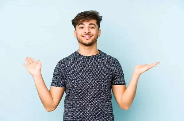 Jonge Arabische Man Geïsoleerd Een Blauwe Achtergrond Maakt Schaal Met — Stockfoto