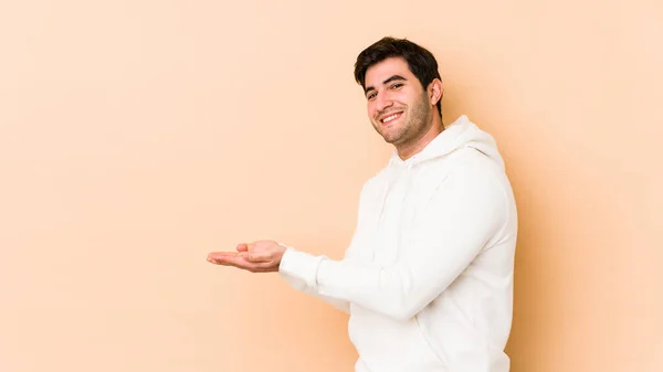 Jongeman Geïsoleerd Beige Achtergrond Met Een Kopieerruimte Een Palm — Stockfoto