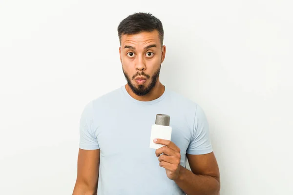 Young South Asian Man Holding Shave Cream Shrugs Shoulders Open — Stock Photo, Image