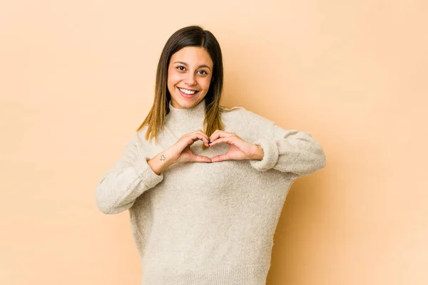 Jovem Mulher Isolada Fundo Bege Sorrindo Mostrando Uma Forma Coração — Fotografia de Stock