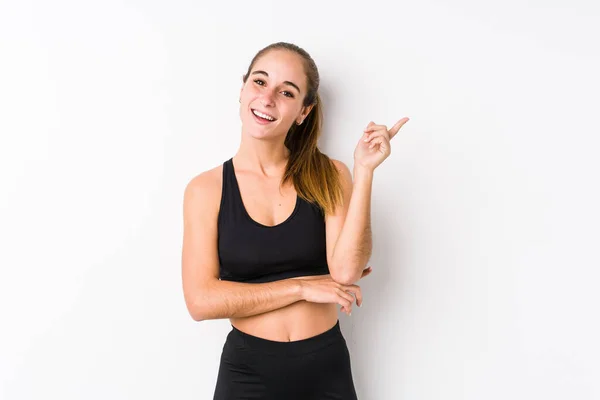 Joven Mujer Fitness Caucásica Posando Fondo Blanco Sonriendo Alegremente Señalando —  Fotos de Stock