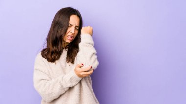 Genç melez İspanyol kadın, kötü bir hareketin ardından acı çeken dirsek masajı yapıyor..