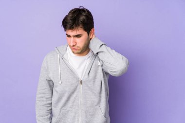 Mor arka planda izole edilmiş genç bir adam stresten dolayı boynu ağrıyor, masaj yapıyor ve elle dokunuyor..