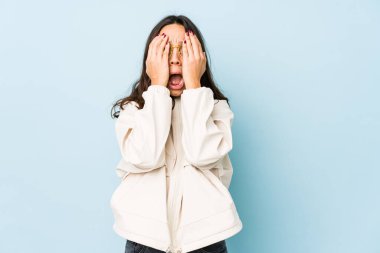 Genç, melez İspanyol bir kadın izole edilmiş, yüzünün yarısını avuç içiyle kaplayarak eğleniyor..