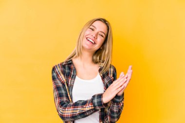 Sarışın, beyaz bir kadın. Sarı arka planda izole edilmiş. Enerjik ve rahat..