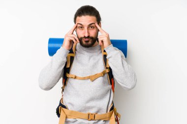 Beyaz bir arka planda izole edilmiş genç bir sırt çantalı adam bir göreve odaklanmış, işaret parmaklarını işaret ediyor..