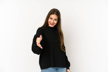 Beyaz arka planda izole edilmiş genç beyaz kadın selamlaşma jesti olarak kameraya elini uzatıyor..