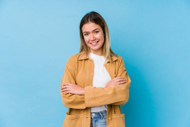 Kendine güveni tam genç bir beyaz kadın, kararlılıkla kollarını kavuşturuyor..