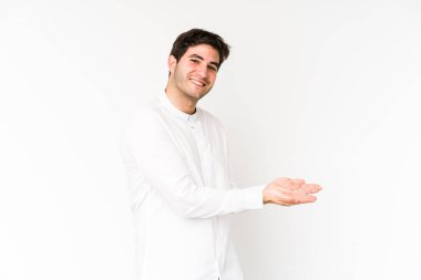 Beyaz arka planda izole edilmiş genç bir adam avucunun içinde bir kopya alanı tutuyor..