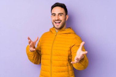 Mor arka planda izole genç beyaz adam kameraya sarıldığı için kendinden emin hissediyor..