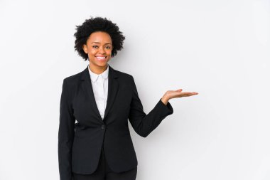 Orta yaşlı Afro-Amerikalı iş kadını beyaz bir arkaplan karşısında bir avuç içinde fotokopi alanı ve belinde bir el daha gösteriyor..