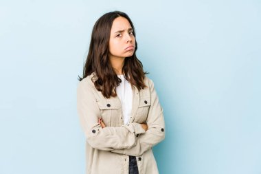Latin kökenli genç bir kadın hoşnutsuzca kaşlarını çatmış, kollarını kavuşturmuş..