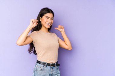 Mor arka planda izole edilmiş genç Hintli kadın gururlu ve kendinden emin hissediyor, örnek olarak..