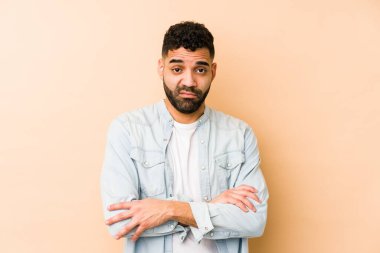 Genç, melez Arap bir adam, kameraya alaycı bir ifadeyle bakarak mutsuz bir şekilde izole edilmiş..