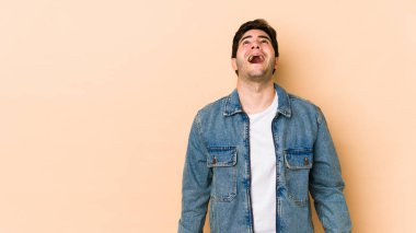 Bej arka planda izole edilmiş genç bir adam çok kızgın, öfkeli ve sinirli bağırıyor..