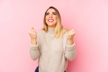 Orta yaşlı bir kadın soyutlanmış arka planda gamsız ve heyecanlı bir şekilde tezahürat yapıyor. Zafer konsepti.