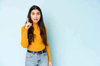 Mavi arka planda izole edilmiş genç Hintli kadın bir fikri, ilham konsepti var..