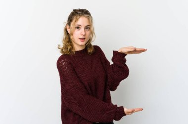 Beyaz arka plandaki genç beyaz kadın elleri arasında bir kopya alanı tutarken şok ve hayrete düştü..