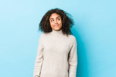Young african american curly hair woman dreaming of achieving goals and purposes