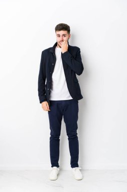 Tüm vücudu genç, beyaz bir adam tırnak yiyor, gergin ve endişeli..