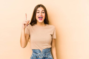 Beyaz tenli genç bir kadın bej arka planda izole edilmiş. Bir fikri, ilham verici bir konsepti var..