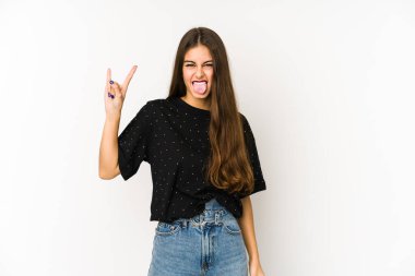 Beyaz arka planda izole edilmiş genç beyaz kadın parmaklarıyla taş hareketi gösteriyor.