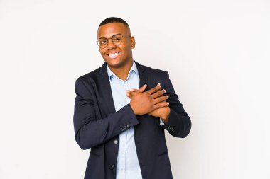 Beyaz arka planda izole edilmiş genç iş adamı, avuçlarını göğsüne bastıran dostça bir ifadeye sahiptir. Aşk konsepti.