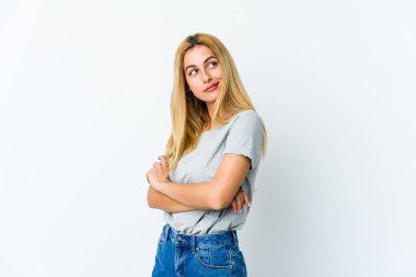 Beyaz arka planda izole edilmiş genç sarışın kadın hedeflere ve amaçlara ulaşma hayali kuruyor.