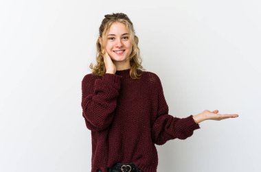 Beyaz arka planda oturan beyaz tenli genç bir kadın avucunun içinde fotokopi alanı tutuyor, el üstünde tutuyor. Şaşırmış ve mutlu..