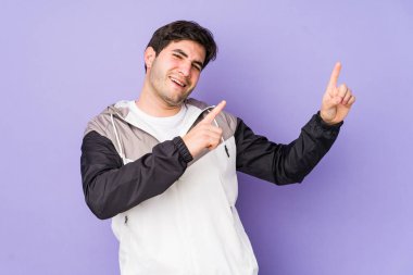 Mor arka planda yaşayan genç adam dans ediyor ve eğleniyor..