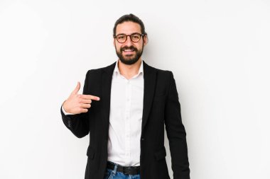 Beyaz arka planda yaşayan beyaz tenli genç bir iş adamı gömleğinin fotokopi odasını işaret ediyor, gururlu ve kendinden emin.