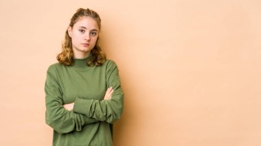 Bej arka planda izole edilmiş beyaz bir kadın. Sıkılmış, yorgun ve dinlenmeye ihtiyacı var..